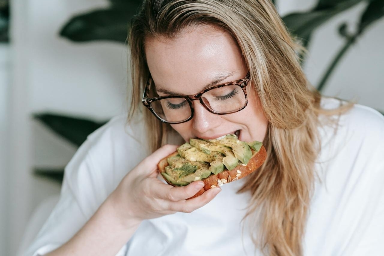 woman eating avocado pexels